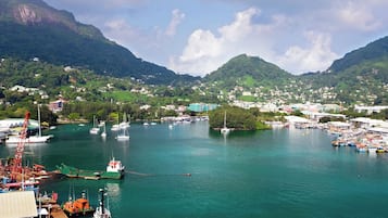A coastal town with a marina, boats, and a mountainous backdrop.