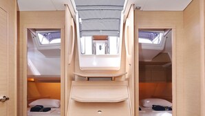 A compact, well-lit room with a skylight, two beds, and a central staircase. - Sun-Kissed Sailing Adventure in Istria, Croatia (Pula)