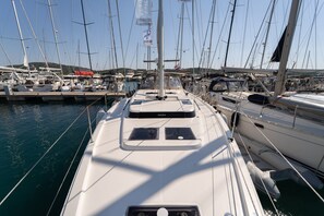 Ein Yachthafen mit mehreren Segelbooten, ein klarer Himmel und ruhiges Wasser.