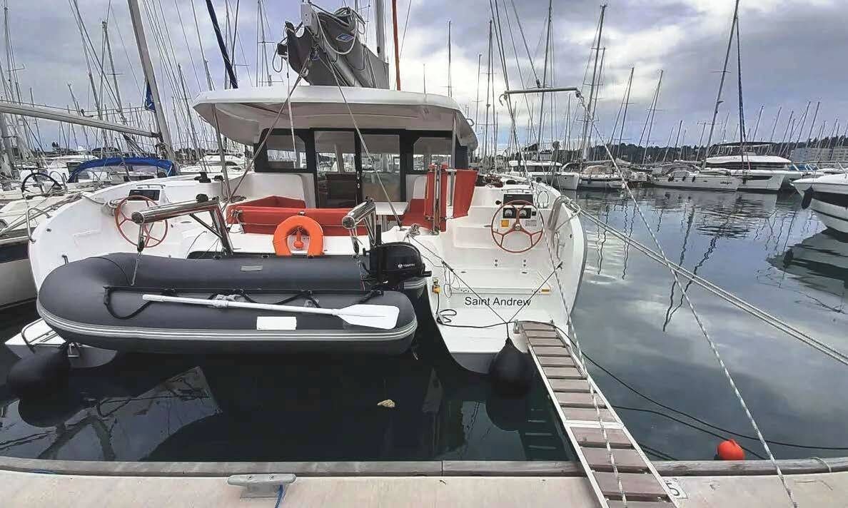 Un bateau était amarré dans une marina, parmi d’autres bateaux. On pouvait y voir un volant, un gilet de sauvetage et le nom « Saint Andrew » peint sur la coque.