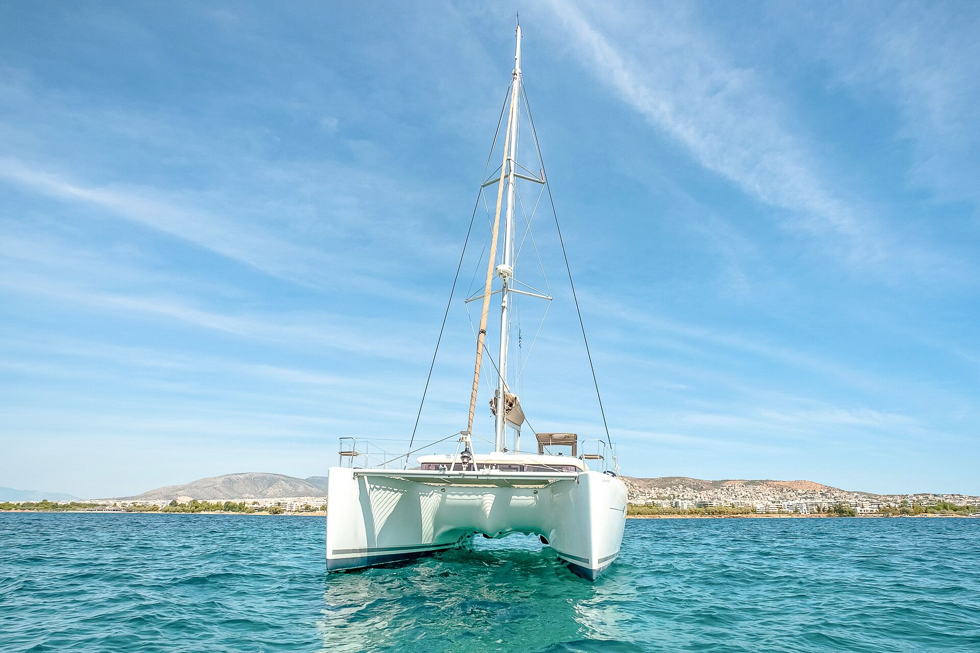 Ein Segelboot auf ruhigem Wasser unter blauem Himmel.