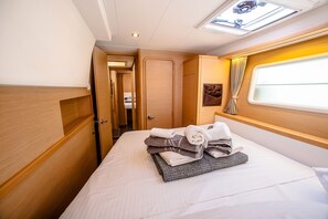Una cabana senzilla i ben il·luminada, amb un llit, una petita finestra i una porta que condueix a una altra habitació.