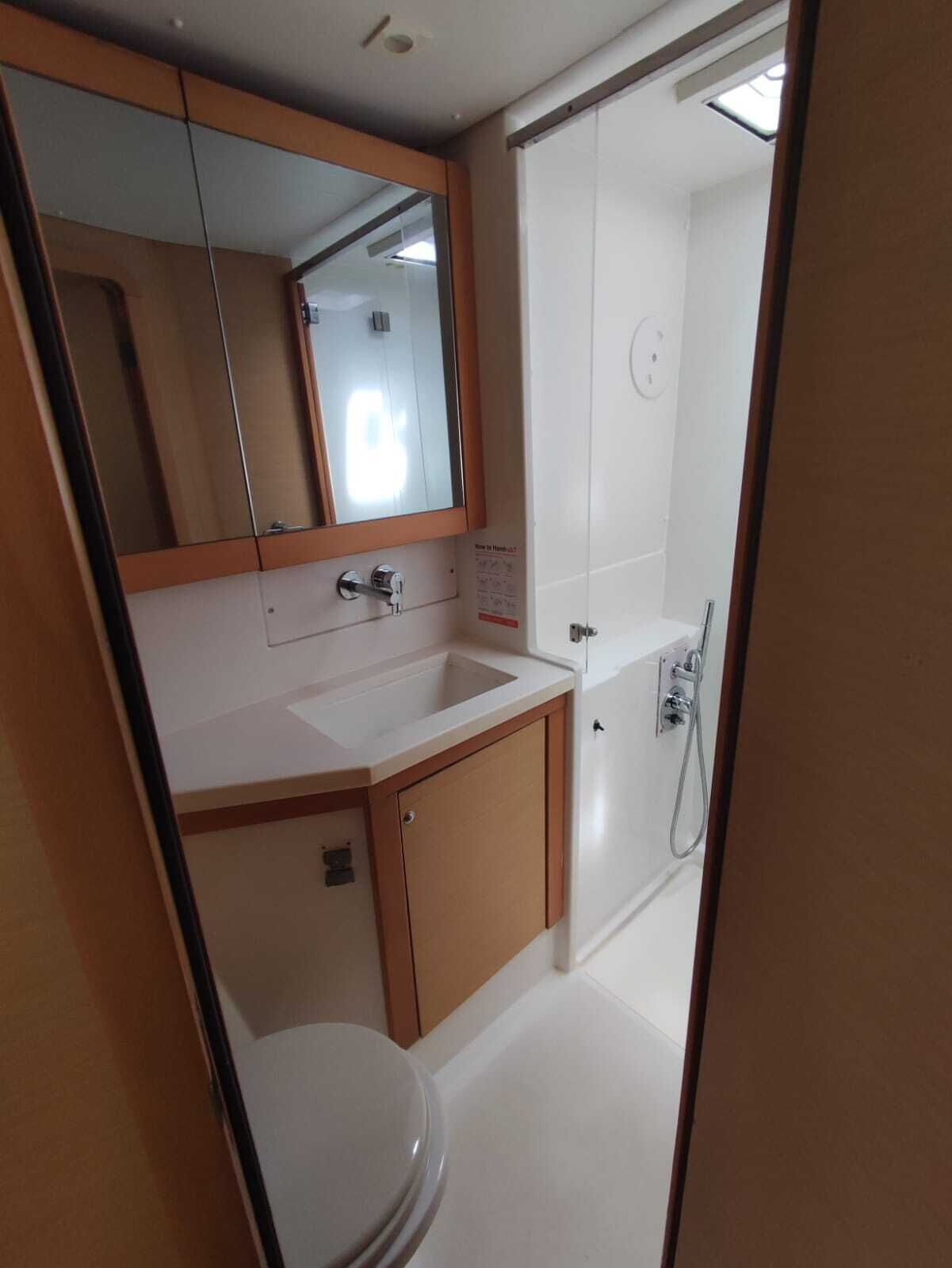 Une salle de bain équipée de toilettes, d’un lavabo, d’un miroir et d’une douche.