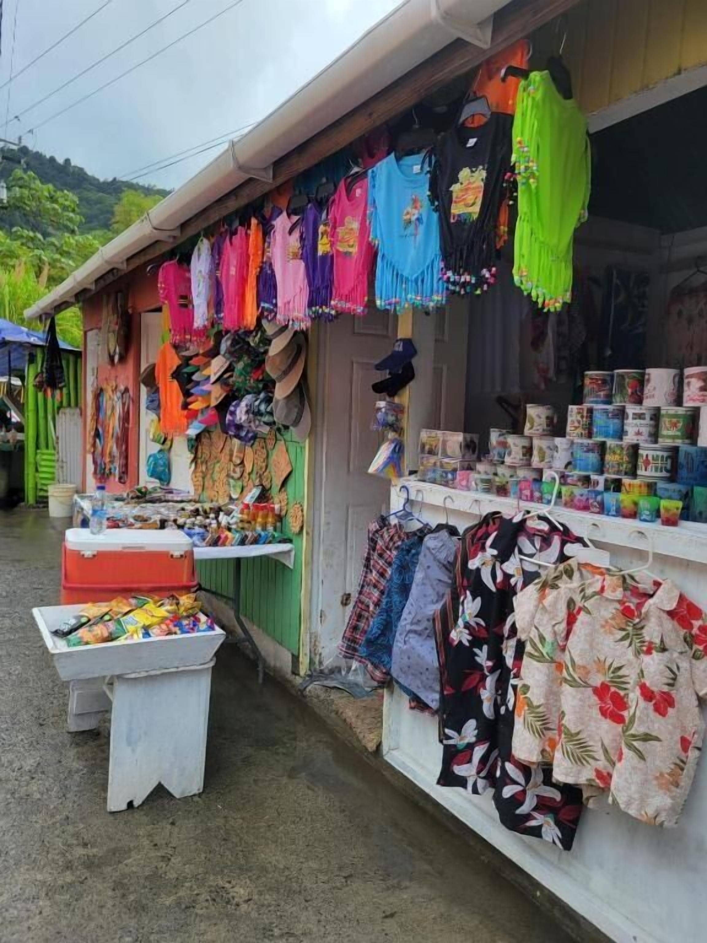 A shop with various colorful fabrics and clothing items displayed outside.