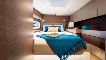 A bedroom with a bed, a skylight, a bedside table, and a nightstand.