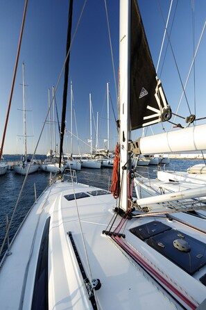 A marina with multiple sailboats docked, featuring white hulls and masts. - Sun-Kissed Sailing Adventure in the Dodecanese Islands (Rodos)