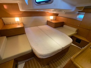 A compact, well-lit cabin with a bed, bedside tables, and a small window. - Sun-Kissed Sailing Adventure in the Sporades Islands from Volos, Thessaly (Volos)