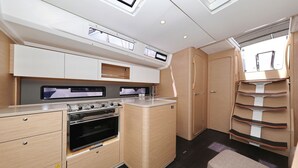 A compact kitchenette with a stove, oven, and upper cabinets. - Sun-Kissed Sailing Adventure in Sibenik, Croatia (Primošten)