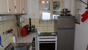 Eine Küche mit Herd, Kühlschrank und einem Fenster.