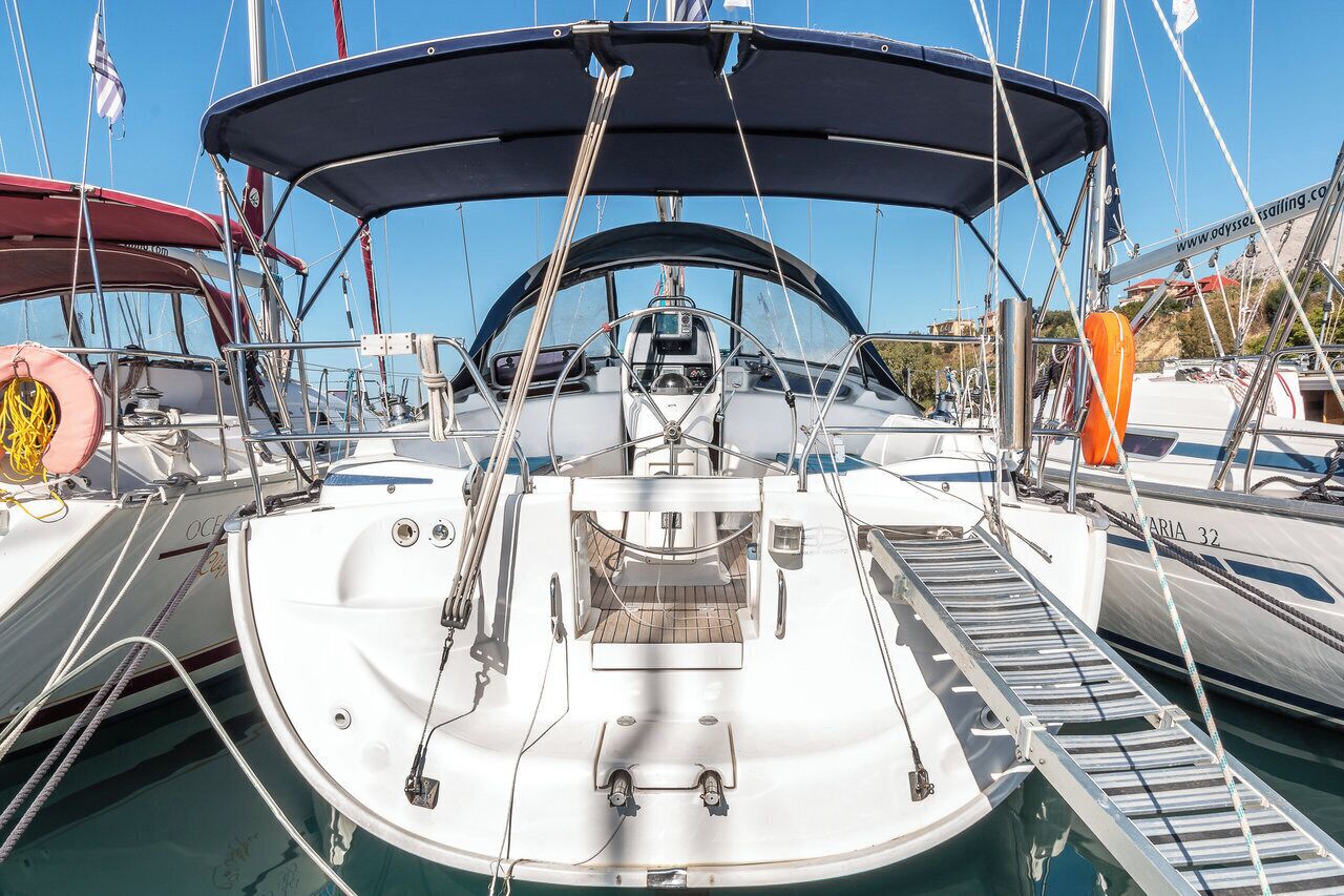 Ein Yachthafen mit vertäuten Booten, darunter ein weißes Boot mit einer überdachten Deckfläche und ein rotes Boot mit einem Rettungsring.