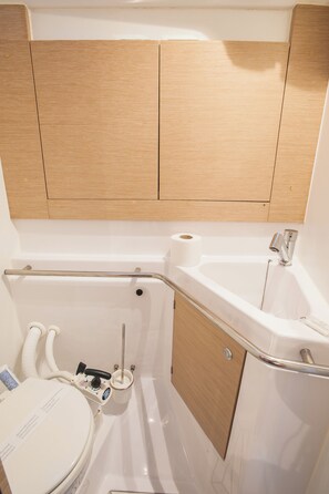 Une petite salle de bain comprenant des toilettes, un bidet et un petit lavabo.