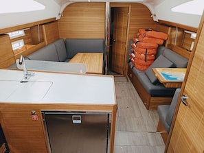 Ein kompaktes Wohnmobil-Interieur mit einer Küchenzeile, einer Sitzecke und Stauräumen.