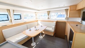 A compact kitchen with a dining area, a built-in bench, and a small table. - Sun-Kissed Sailing Adventure in the Ionian Islands, Lefkada (Lefkada)