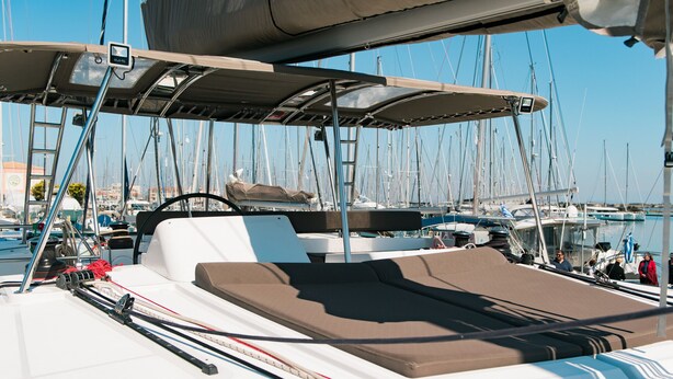 A boat deck with a cushioned seating area, a steering wheel, and various ropes and lines. - Sun-Kissed Sailing Adventure in the Ionian Islands, Lefkada (Lefkada)