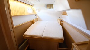 A compact, well-lit interior with a single bed, a small table, and a window with curtains. - Sun-Kissed Sailing Adventure in the Ionian Islands, Lefkada (Lefkada)