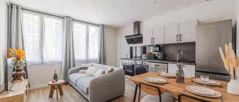 Ein modernes Apartment mit Essbereich, Küche und Wohnzimmer.