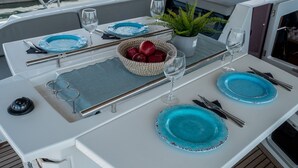 Une table à manger avec des assiettes bleues, des couverts et un saladier rempli de pommes rouges.