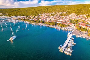 An aerial view of a coastal town with a marina, boats, and houses.