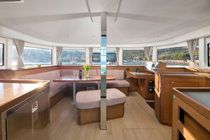 A modern interior with a dining area, seating, and a kitchen. - Sun-kissed Sailing Adventure in Split-Dalmatia, Croatia (Trogir)