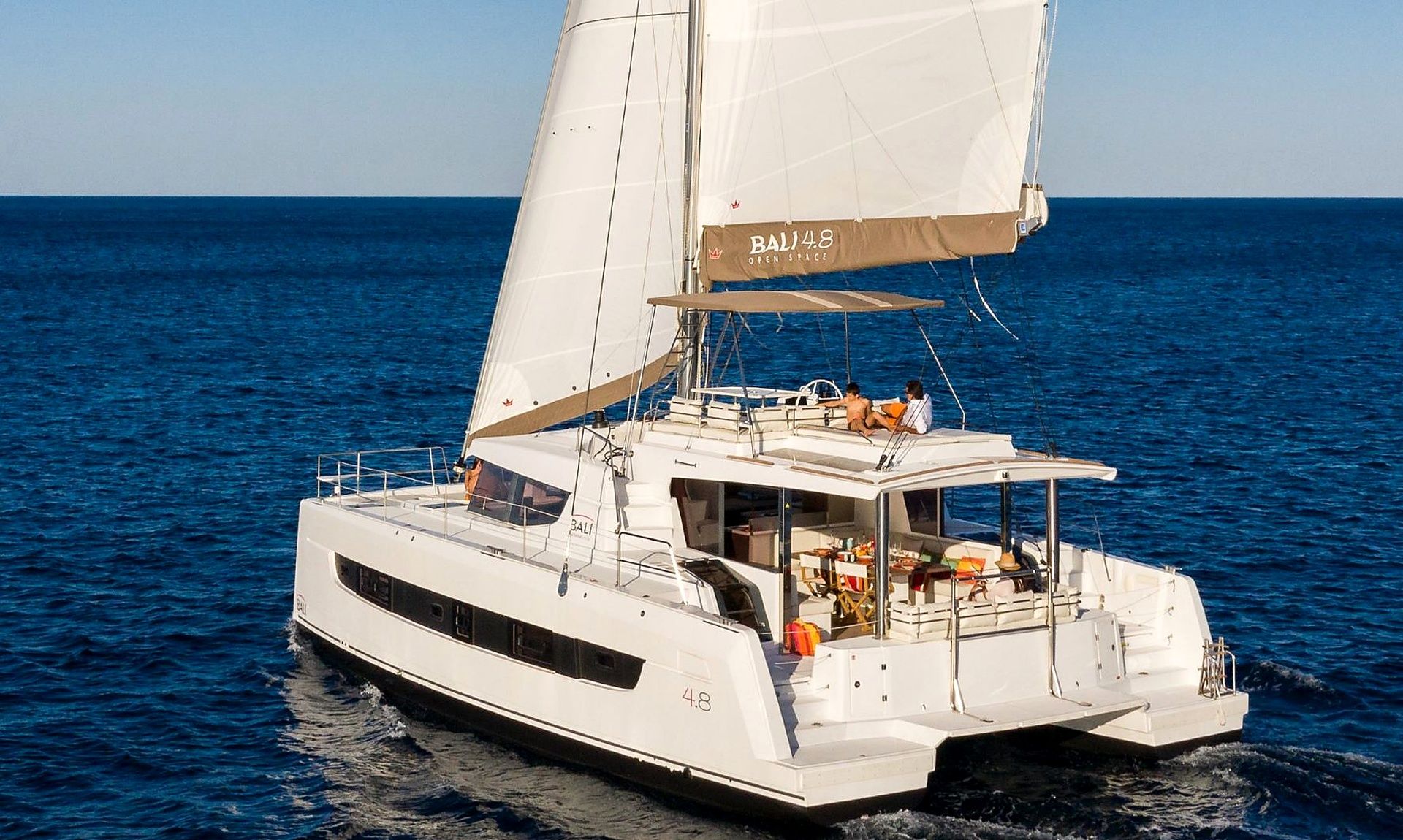 A white yacht with a cabin and deck area, sailing on the water.
