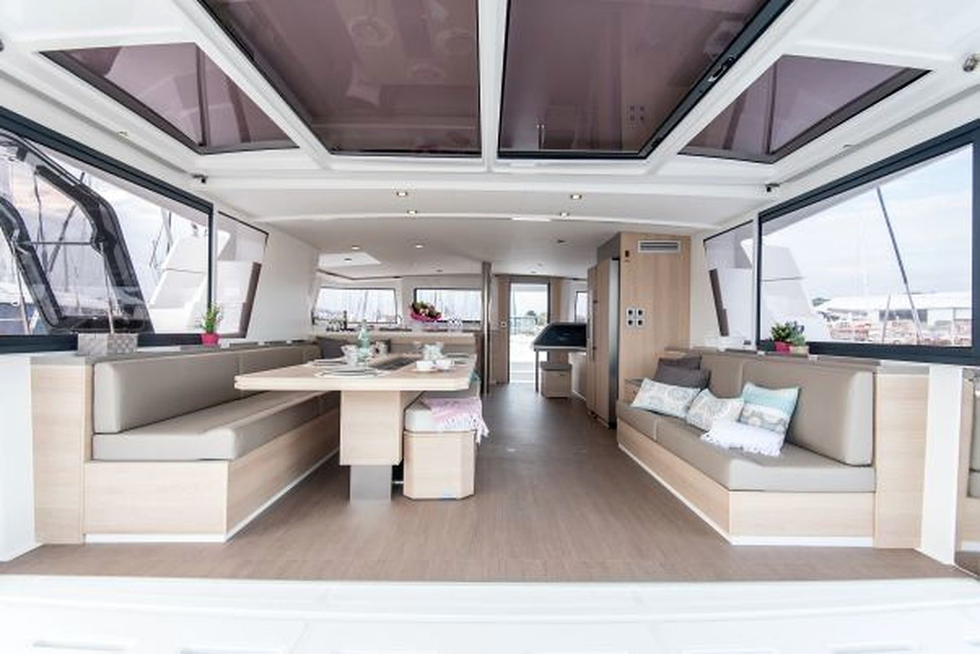A modern interior with a central dining area, seating, and large windows.