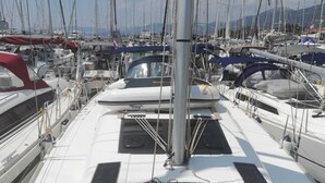 Ein Yachthafen mit mehreren Segelbooten, die vertäut sind, mit einem zentralen Mast und einem überdachten Bereich.