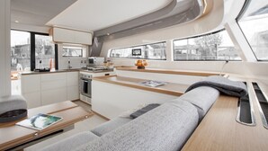 A modern interior with a kitchen, seating area, and large windows. - Sun-kissed Sailing Adventure in Split-Dalmatia, Croatia (Seget Donji)