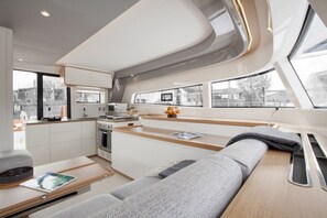 A modern interior with a kitchen, seating area, and large windows. - Sun-kissed Sailing Adventure in Split-Dalmatia, Croatia (Seget Donji)
