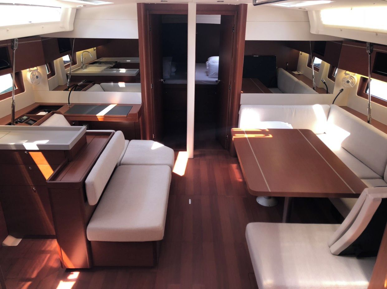 A compact interior with a central table, two sofas, and a small bed.