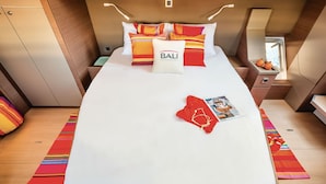 A compact, well-lit bedroom with a bed, pillows, a nightstand, and a window. - Caribbean Bliss: Sun-soaked Sailing Adventure from Nassau, Bahamas (Nassau)