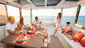 A yacht interior with a dining area, seating, and a view of the sea. - Caribbean Bliss: Sun-soaked Sailing Adventure from Nassau, Bahamas (Nassau)