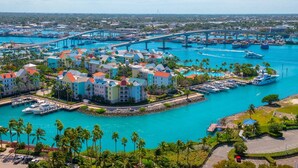A marina with boats, a bridge, and a resort with colorful buildings. - Caribbean Bliss: Sun-soaked Sailing Adventure from Nassau, Bahamas (Nassau)