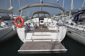 Ein Bootsdeck mit Steuer, Rettungsflossen und einem kleinen Wohnbereich.