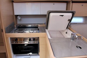 A compact kitchenette with a stove, oven, and sink. - Sun-Kissed Sailing Adventure in the Ionian Islands, Lefkada (Lefkada)