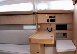 A compact RV interior with a kitchenette, a small table, and a cushioned bench. - Sun-Kissed Sailing Adventure in the Ionian Islands, Lefkada (Lefkada)
