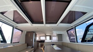 A yacht interior with a dining area, seating, and a galley. - Sun-Kissed Sailing Adventure in Split, Croatia (Kaštel Gomilica)