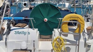 En bådække med et grønt markise, en gul redningskrans og et hvidt skilt med 'Molly's' skrevet på.