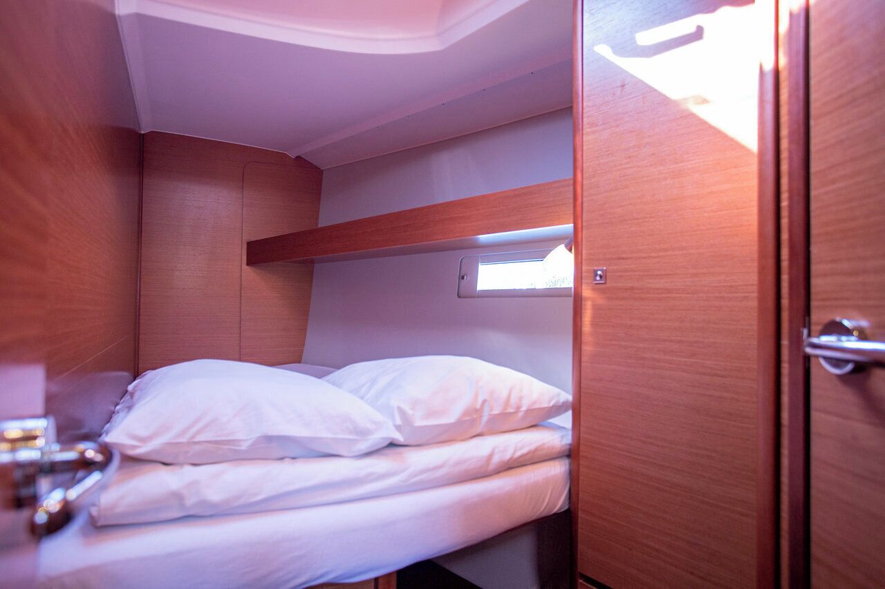 A compact cabin with a bunk bed, a small window, and a wooden door.