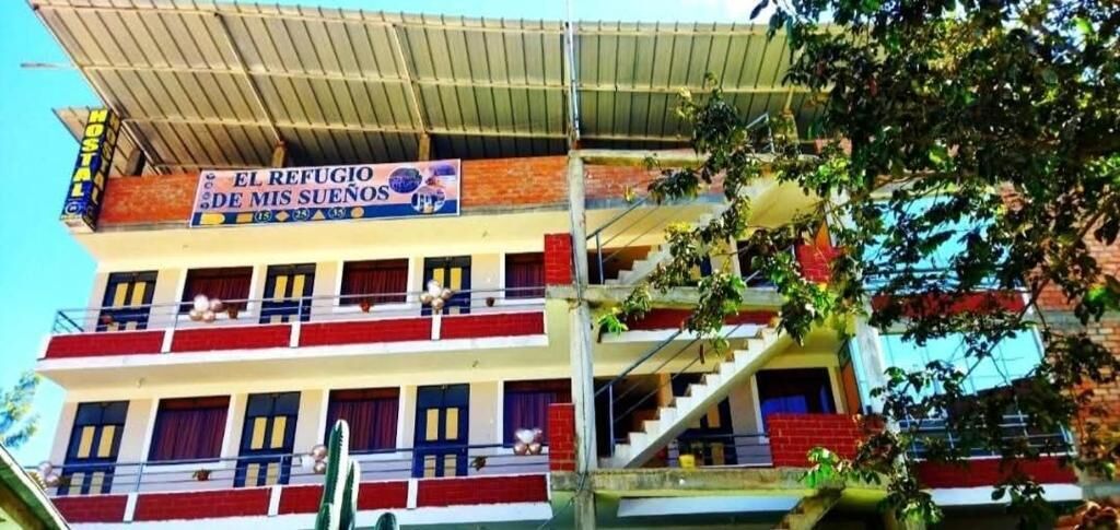 Um edifício de vários andares com varandas e uma placa que diz 'EL REFUGIO DE MIS SUEÑOS'.