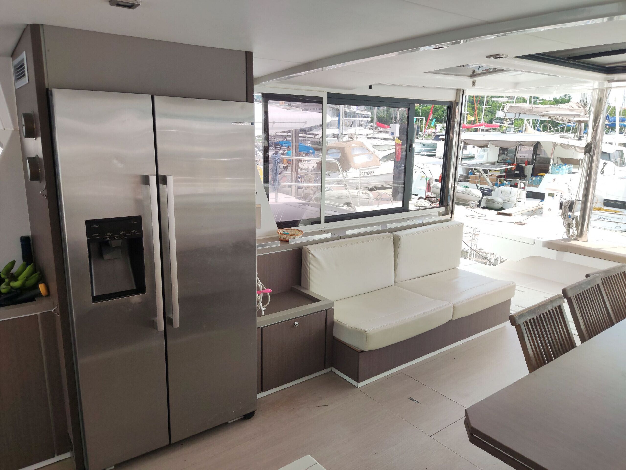 Una cocina moderna con un refrigerador de acero inoxidable, un dispensador de agua integrado y una zona de estar con un banco acolchado.