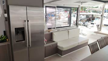 Una cocina moderna con un refrigerador de acero inoxidable, un dispensador de agua integrado y una zona de estar con un banco acolchado.