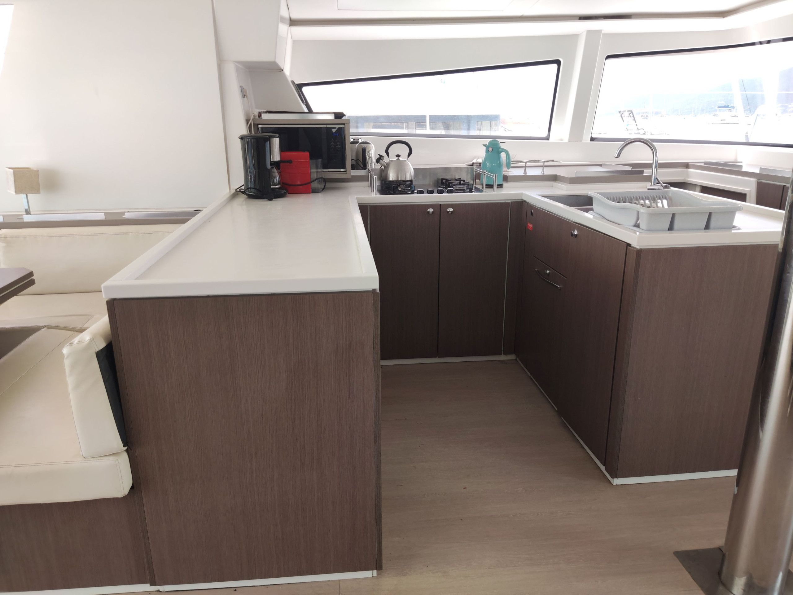 Una cocina compacta con una isla central, un fregadero y un ventanal que proporciona luz natural.