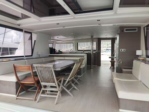 A modern kitchen with a central island, seating area with chairs, and large windows offering views of the marina.
