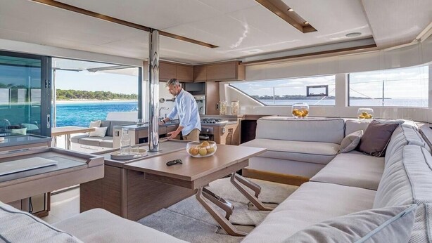 A modern interior with a dining area, kitchen, and seating. - Sun-Kissed Sailing Adventure in Islas Sarónicas (Alimos)
