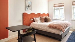A bedroom with a bed, a desk, and a window. - The Collector's House by Muse (Reykjavík)