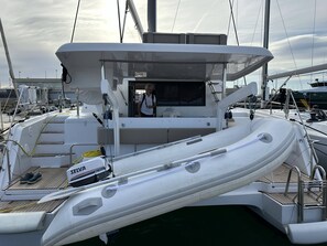 A yacht with a covered deck, a seating area, and a motorized outboard. - Sun-Kissed Sailing Adventure in Valencia (Valencia / València)
