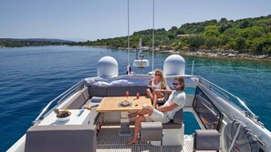 A boat with a table, chairs, and a person reading. - Sun-kissed Sailing Adventure in Split-Dalmatia, Croatia (Trogir)