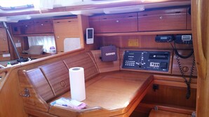 Interior de uma cabana de madeira com um painel de controle, um dispositivo Garmin e um rolo de papel higiênico.