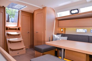 Ein kompaktes Wohnmobil-Interieur mit Essbereich, Sitzgelegenheiten und Stauraumschränken.