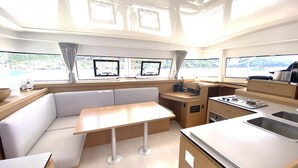 A compact kitchen with a dining area, a stove, and a sink. - Sun-Kissed Sailing: A Luxurious Beach Experience in Valencia (Denia)